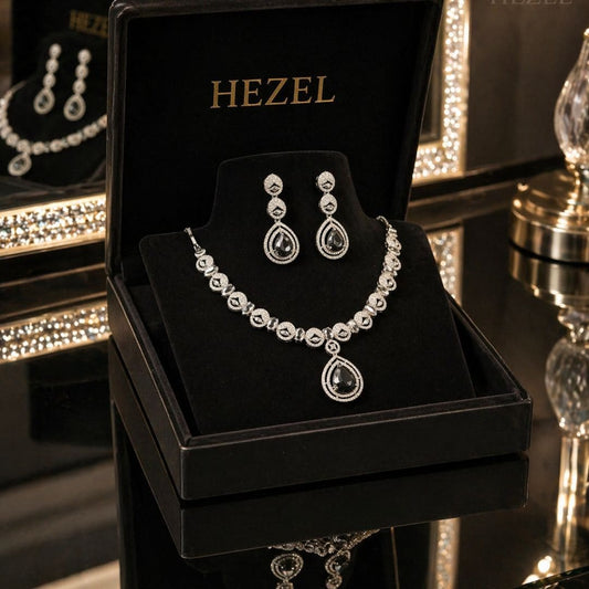Close-up of HEZEL crystal teardrop pendant necklace and matching drop earrings with premium silver finish