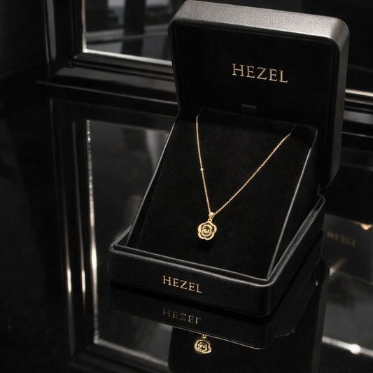 Hezel gold pendant necklace with floral design displayed in premium black jewelry box