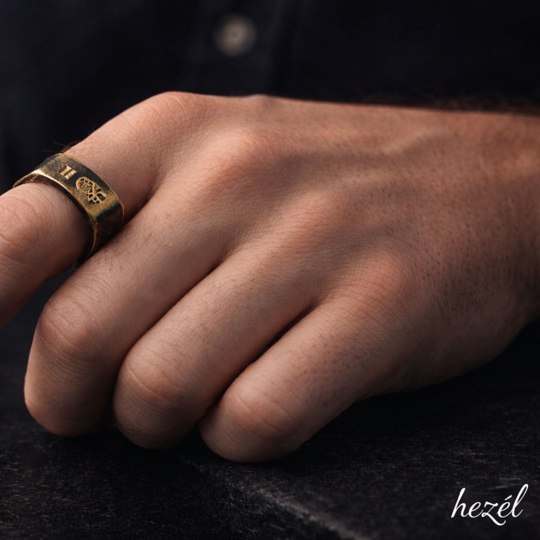 Hezel gold signet ring worn on hand with minimalist dark background