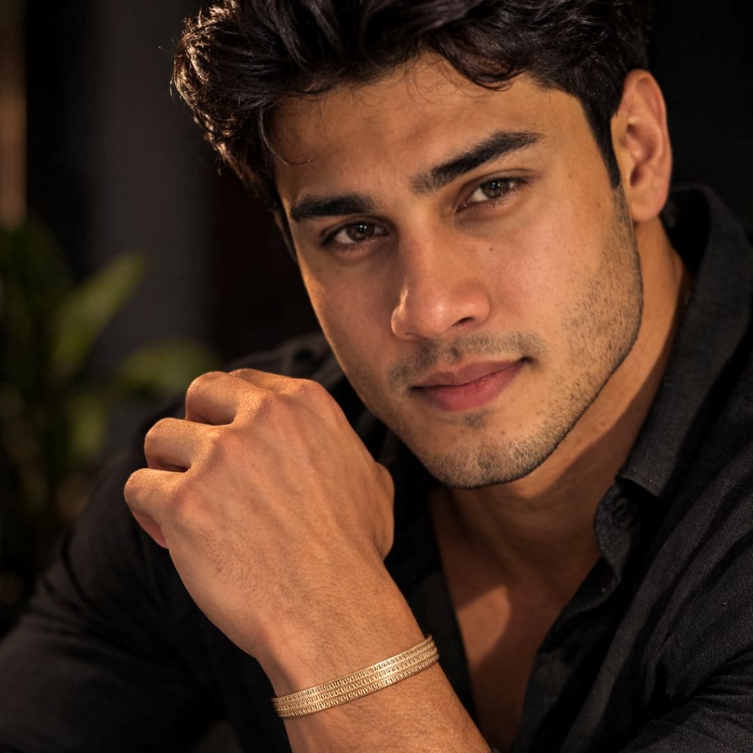 Hezel textured gold bangle worn by a man, styled in a warm, sophisticated lifestyle setting