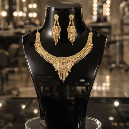HEZEL gold-tone statement necklace set with matching chandelier earrings, elegantly displayed on a black mannequin against a luxurious blurred backdrop.