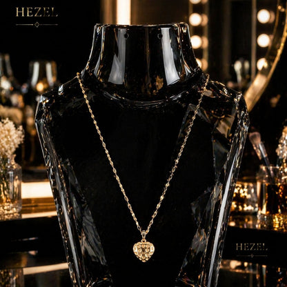 HEZEL gold heart pendant necklace displayed on black mannequin, minimal luxury jewellery for women with elegant studio lighting.