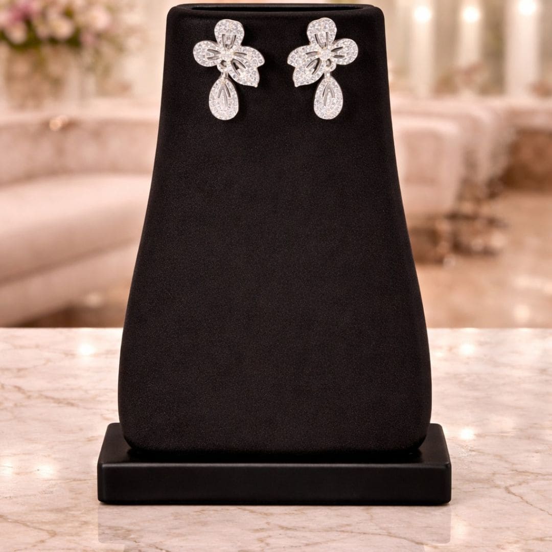 HEZEL floral drop earrings in silver finish displayed on a black mannequin, elegant sparkling design