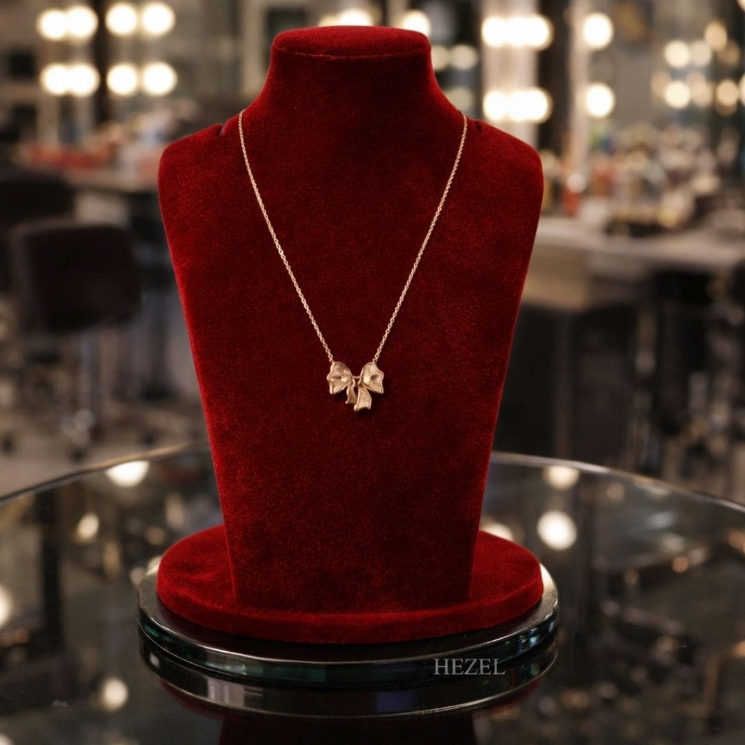 Hezel elegant bow pendant necklace displayed on premium red velvet stand.