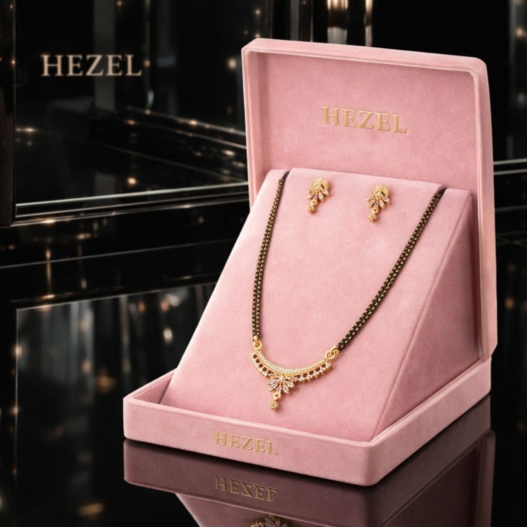 HEZEL premium mangalsutra necklace set with matching earrings displayed in a luxury pink velvet jewelry box on a glossy black background.