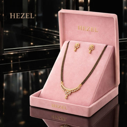 HEZEL premium mangalsutra necklace set with matching earrings displayed in a luxury pink velvet jewelry box on a glossy black background.