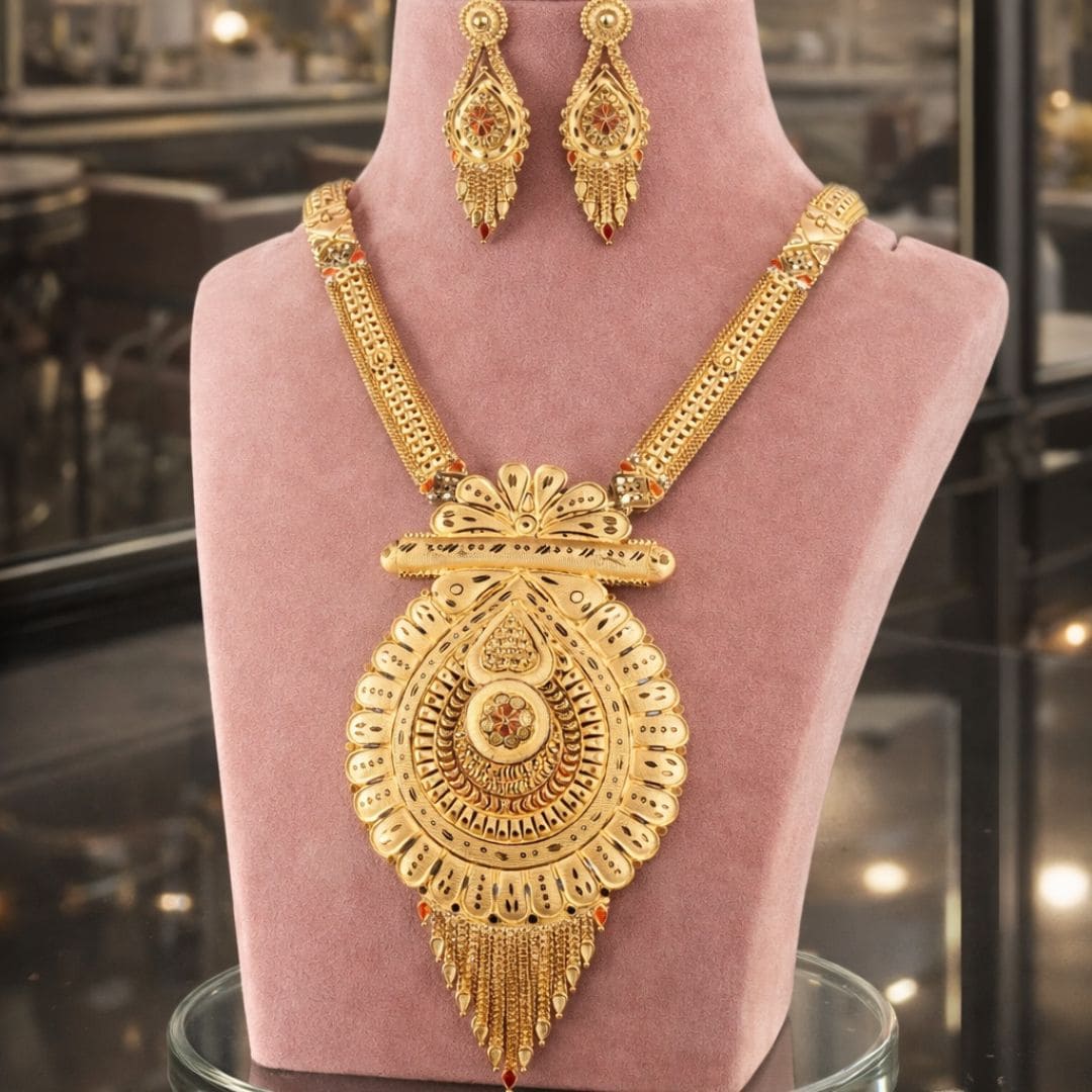 HEZEL traditional gold-tone statement necklace with intricate pendant and matching earrings, displayed on a premium mannequin.