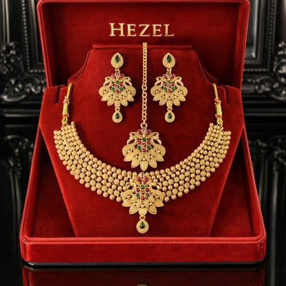 HEZEL gold-tone beaded necklace set with floral pendant, matching earrings, and maang tikka in a premium red jewelry box