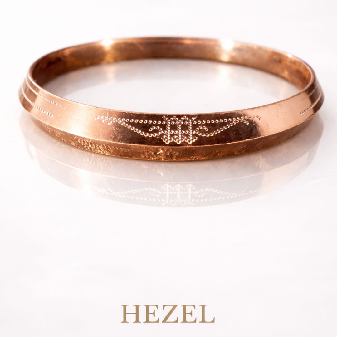 Hezel engraved gold bangle with intricate detailing, showcased on a clean minimal background