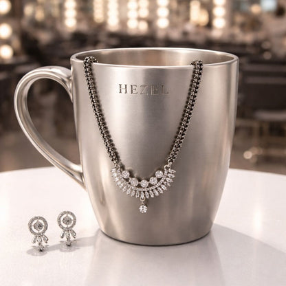 Elegant silver-tone mangalsutra set with matching earrings displayed on a premium HEZEL metallic mug.