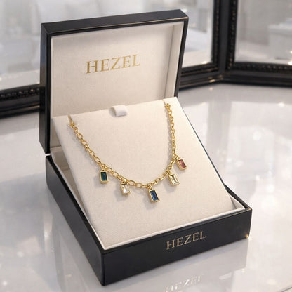 HEZEL gold charm necklace with multicolor rectangular gemstones displayed in a premium white jewelry box