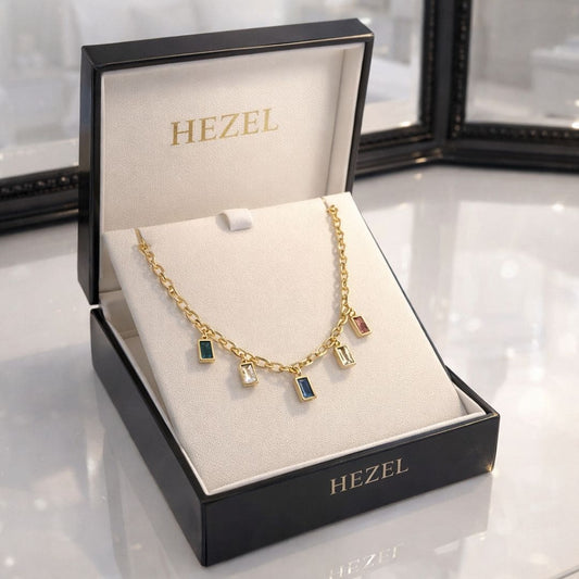 HEZEL gold charm necklace with multicolor rectangular gemstones displayed in a premium white jewelry box