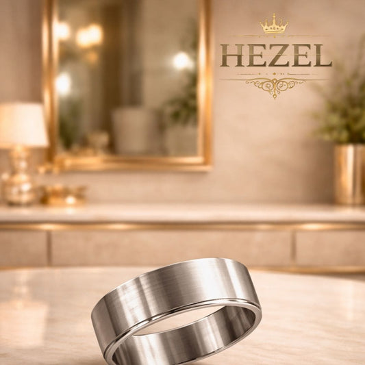 HEZEL minimalist brushed silver band ring with smooth finish displayed on marble surface in elegant luxury background