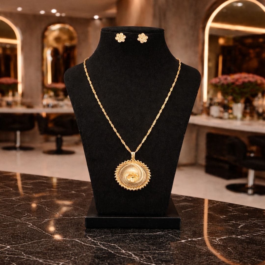 HEZEL gold statement pendant necklace with matching stud earrings on black display bust, elegant traditional design