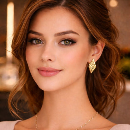 HEZEL gold leaf stud earrings worn by woman in elegant look