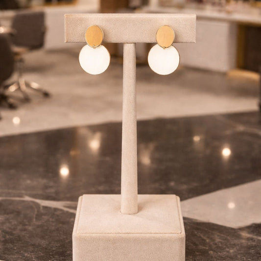 Hezel premium gold and pearl drop earrings displayed on elegant velvet stand in luxury boutique setting