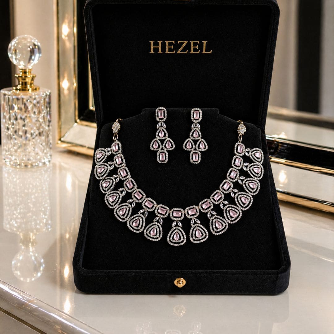 Elegant HEZEL statement necklace featuring teardrop pink gemstones and diamond-style detailing, paired with matching earrings on a premium black display.