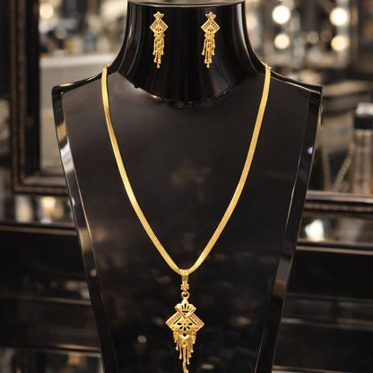 HEZEL gold-tone necklace and earrings set on a glossy black stand with a luxurious boutique background.