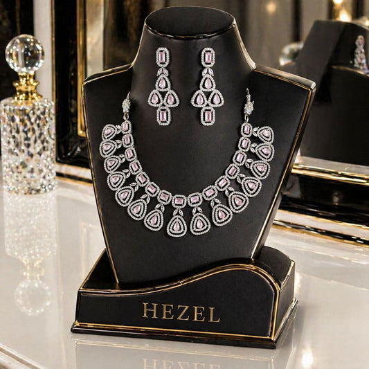 Luxury HEZEL pink stone necklace set with matching drop earrings displayed on a glossy black jewellery stand with gold accents.