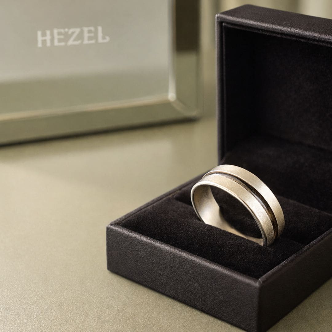 HEZEL minimalist silver band ring with textured center stripe displayed in black jewelry box on clean premium background