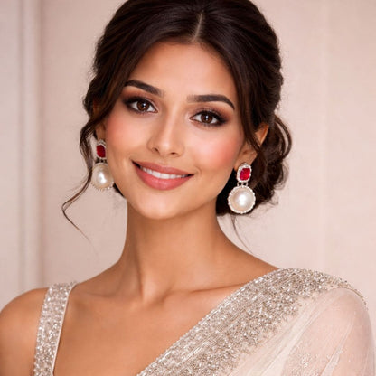 Model wearing red gemstone and pearl drop earrings in elegant bridal style