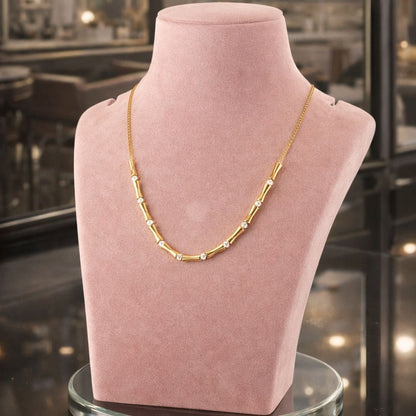 Elegant gold chain necklace with subtle detailing, displayed on a premium pink stand for a refined HEZEL look.