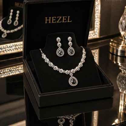 Close-up of HEZEL crystal teardrop pendant necklace and matching drop earrings with premium silver finish