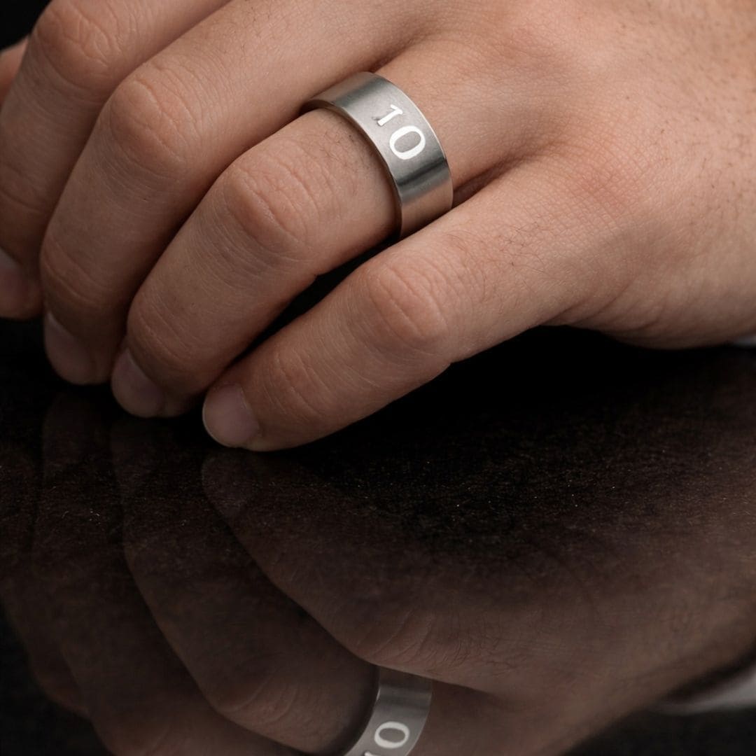 Hezel brand minimalist stainless steel band ring engraved with “10,” worn on hand with a sleek reflective surface background
