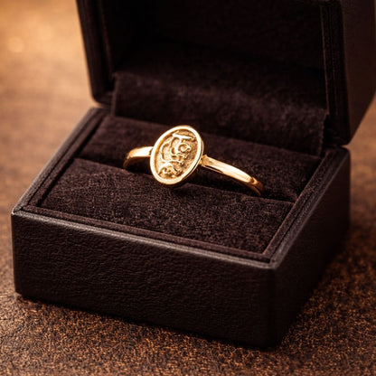 Hezel gold oval filigree ring elegantly presented in a black velvet jewelry box with warm luxury lighting