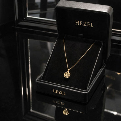 Hezel gold pendant necklace with floral design displayed in premium black jewelry box
