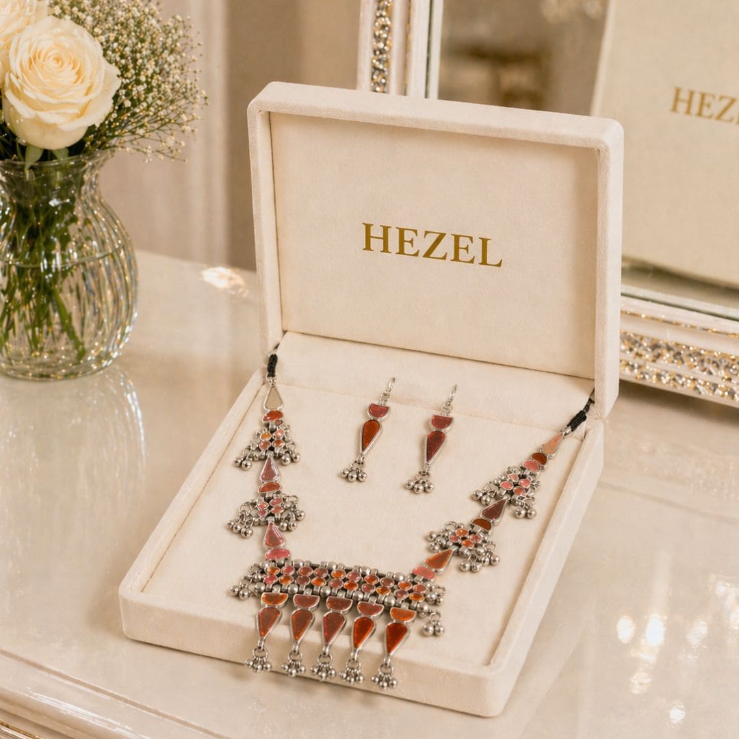 Elegant HEZEL tribal-inspired necklace featuring red enamel detailing and ghungroo-style elements, paired with coordinated earrings