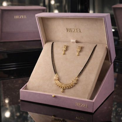 HEZEL black bead mangalsutra set with gold pendant and matching earrings in a premium lavender jewelry box.