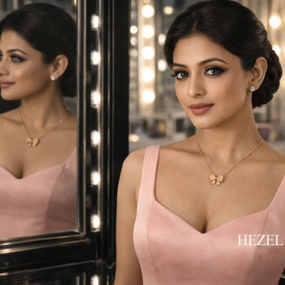 HEZEL butterfly pendant necklace worn by an elegant model in a blush pink dress, styled in a luxurious mirror setting with a delicate rose gold finish.
