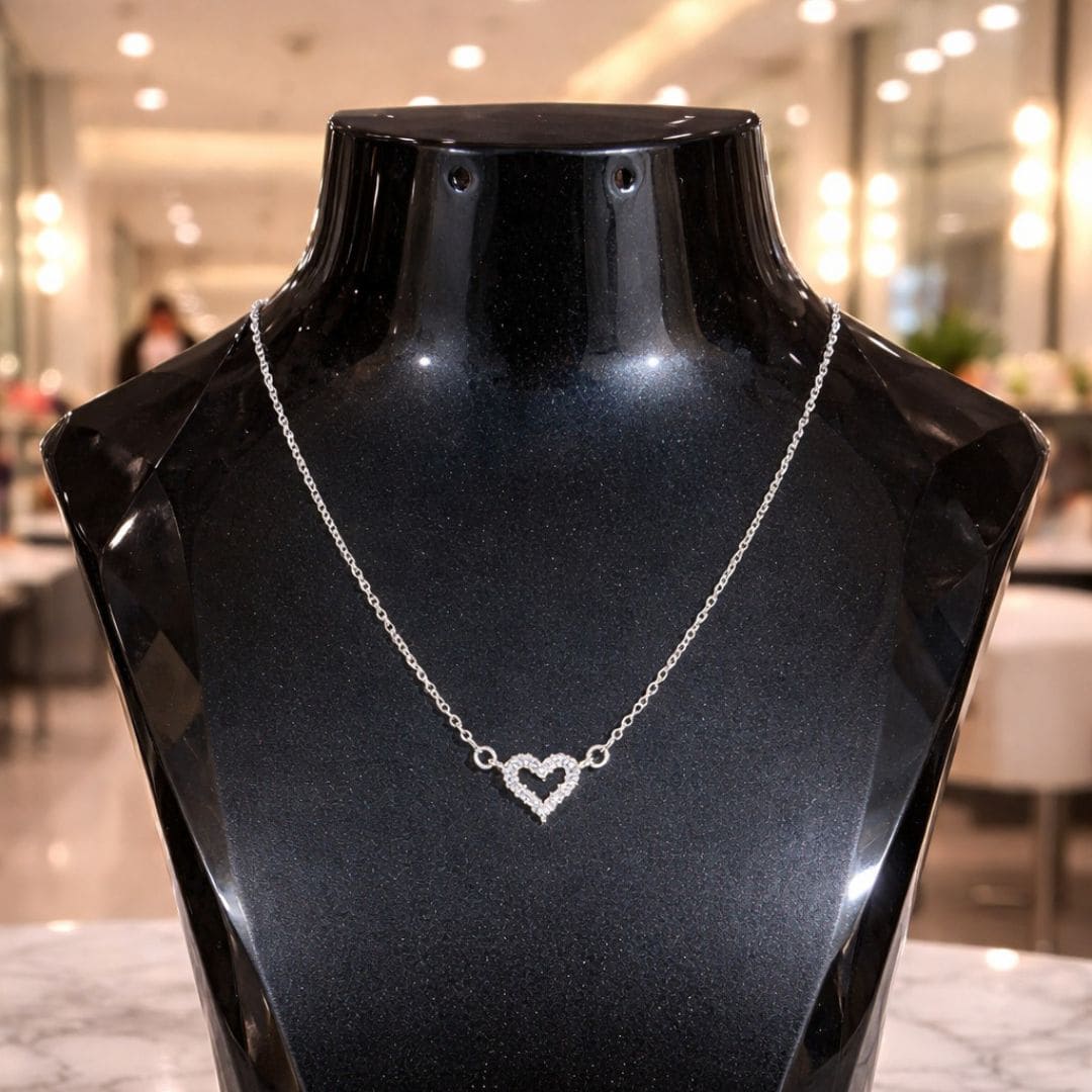 HEZEL heart pendant necklace in silver finish displayed on a black mannequin, elegant minimal jewelry design