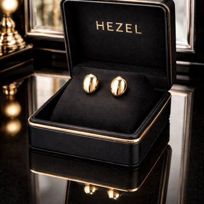 Hezel polished gold stud earrings in a luxury black velvet jewelry box with elegant reflective background