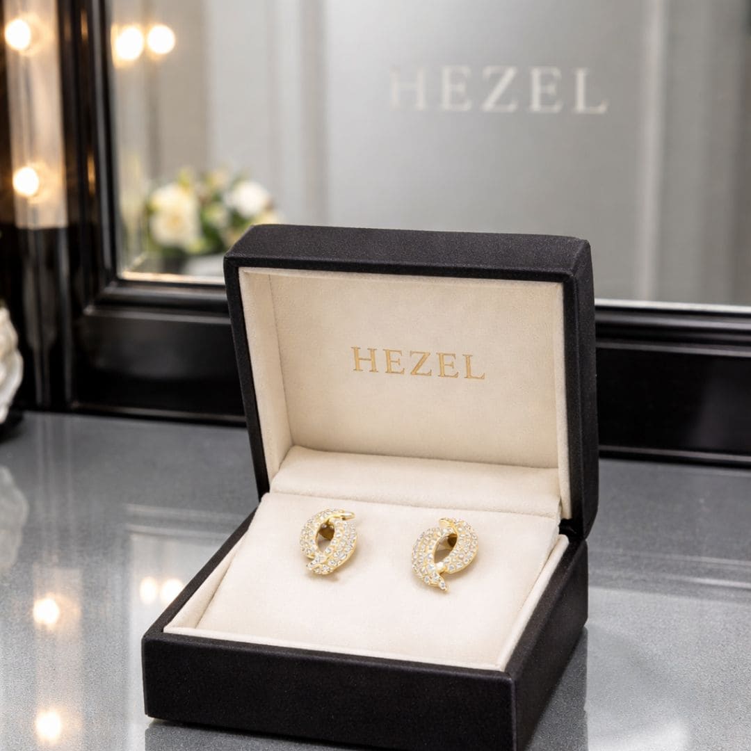 HEZEL gold zircon stud earrings displayed in premium black jewelry box with soft interior