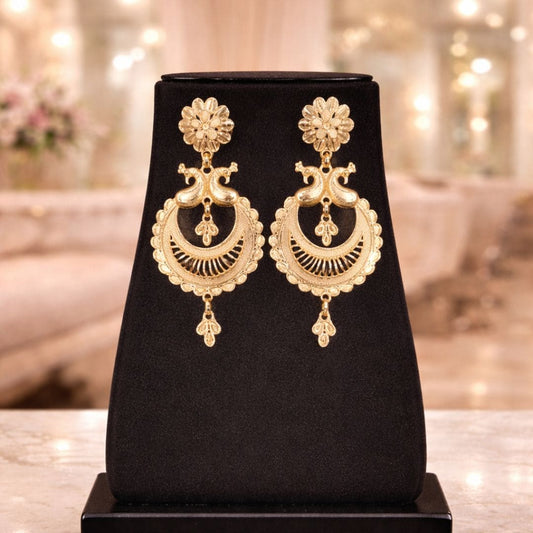 “Hezel gold chandelier earrings with intricate floral and crescent filigree design on black display stand