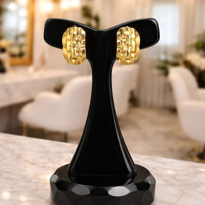 Hezel gold textured stud earrings on black display stand, elegant modern jewelry design.