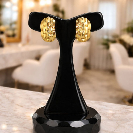 Hezel gold textured stud earrings on black display stand, elegant modern jewelry design.