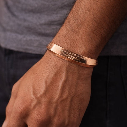 Minimalist gold bangle worn on wrist, featuring fine engraved detailing for a sleek and modern look