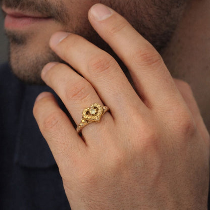 Hezel gold heart ring with vintage detailing and center stone worn on hand