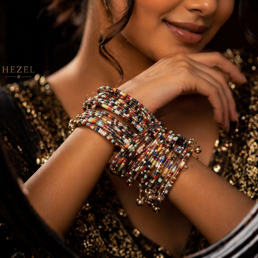 “Multicolor beaded stack bracelets with gold charms worn by a woman, elegant handmade jewelry by Hezel”
