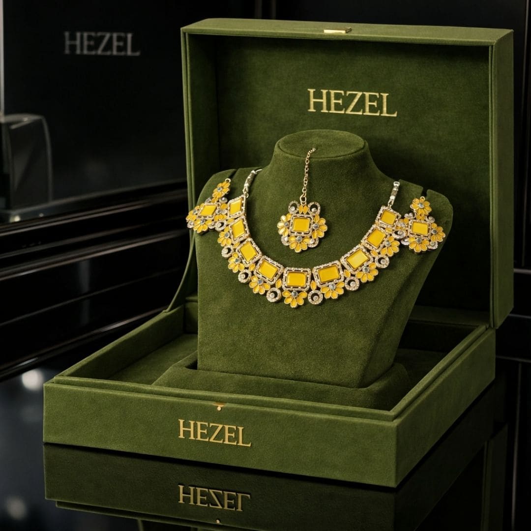 HEZEL premium floral necklace set with matching earrings and maang tikka displayed in a luxury green velvet jewelry box with elegant black background.
