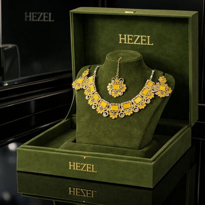 HEZEL premium floral necklace set with matching earrings and maang tikka displayed in a luxury green velvet jewelry box with elegant black background.