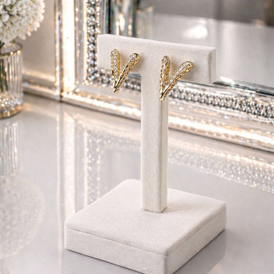 HEZEL luxury gold earrings on premium white velvet display stand with elegant mirror background
