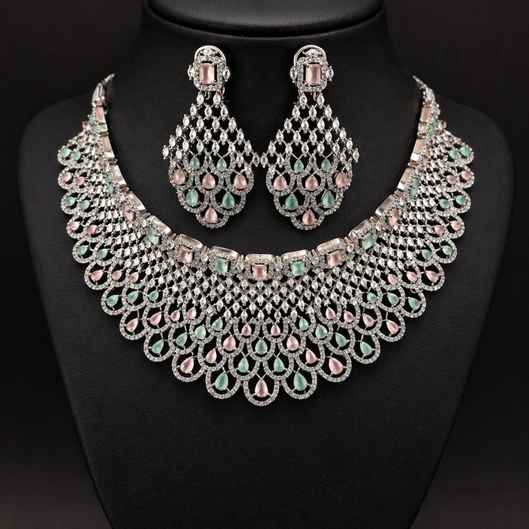 Hezel statement necklace set with pastel green and pink stones, paired with matching chandelier earrings on a black display