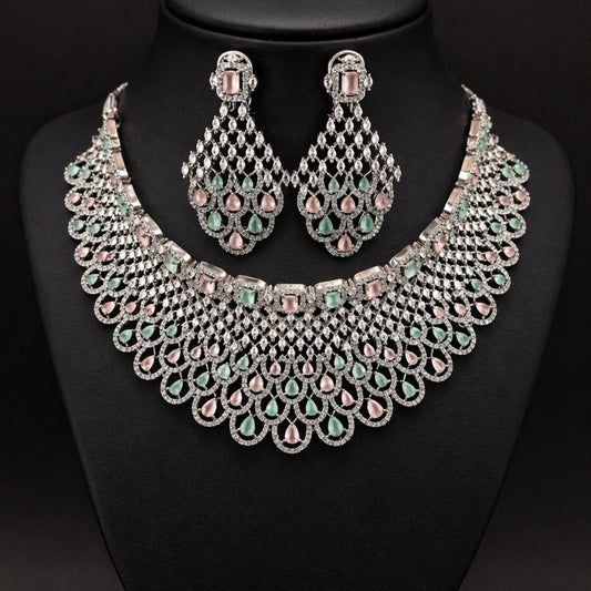 Hezel statement necklace set with pastel green and pink stones, paired with matching chandelier earrings on a black display