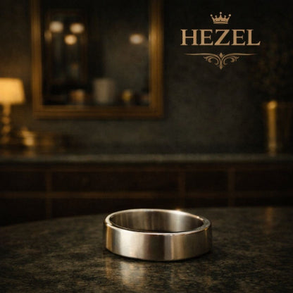 Minimalist silver band ring placed on a premium surface with elegant HEZEL branding in the background, highlighting its clean and timeless design