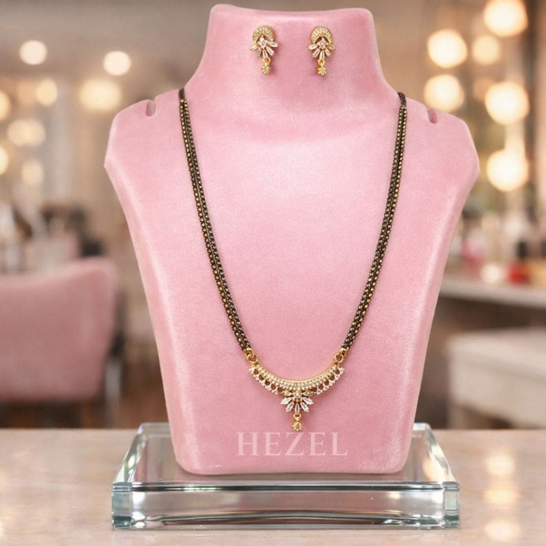 HEZEL elegant mangalsutra set with matching earrings displayed on a pink velvet stand in a premium luxury background