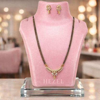 HEZEL elegant mangalsutra set with matching earrings displayed on a pink velvet stand in a premium luxury background